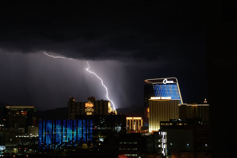 Forked lightning with a long horizontal leader hooks down toward downtown Las Vegas near the Circa and Golden Nugget